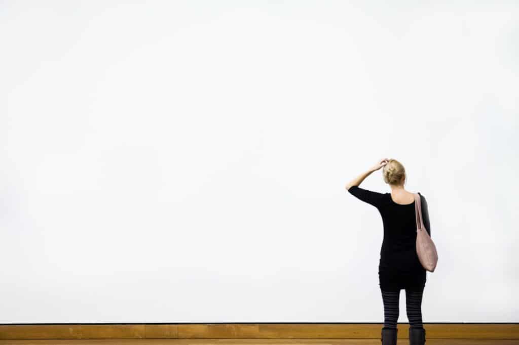 Woman Questioning in front of a Blank Wall