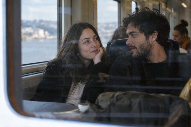 Δύο άνθρωποι σε καφέ μιλούν ήρεμα, χαμογελούν και σχεδιάζουν μια σοβαρή σχέση χωρίς πίεση, με ασφάλεια.