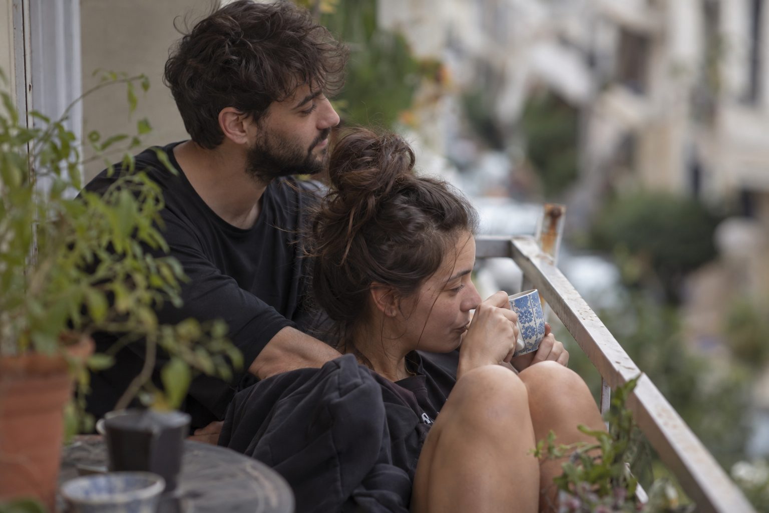 Ζευγάρι αγκαλιασμένο σε καναπέ, στον τοίχο εμφανίζονται τα αστρολογικά σύμβολα Καρκίνου και Λέοντα.
