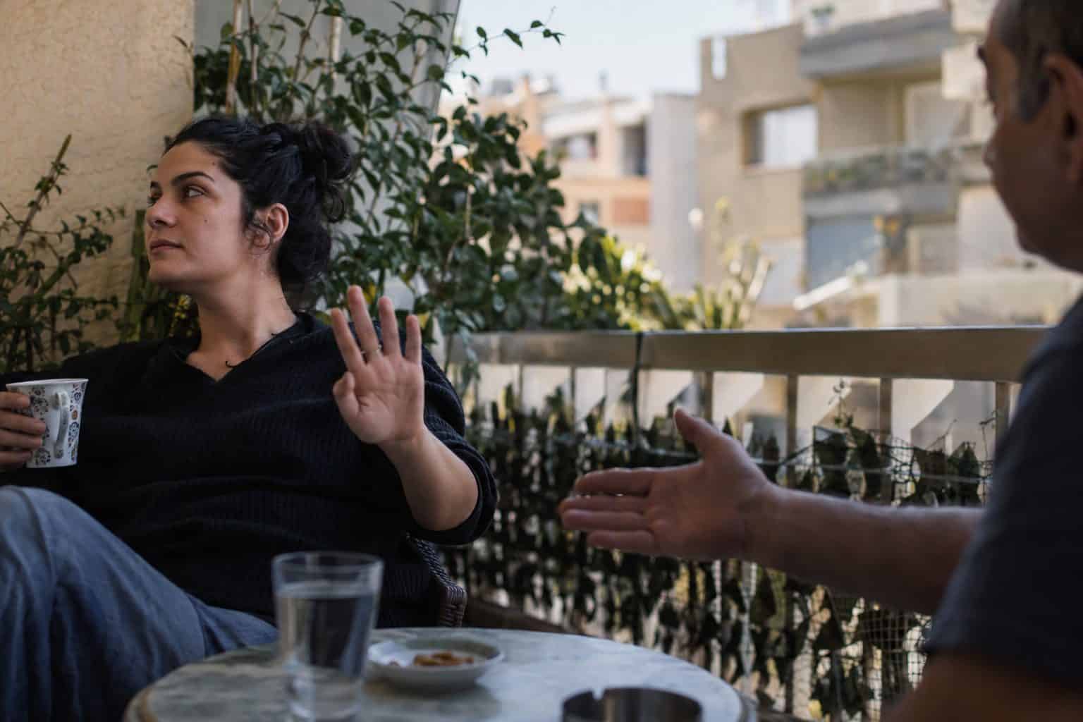 Άτομο σε γραφείο κρατάει παλάμη μπροστά, οριοθετώντας όρια δουλειάς και σχέσεων με ευγένεια.