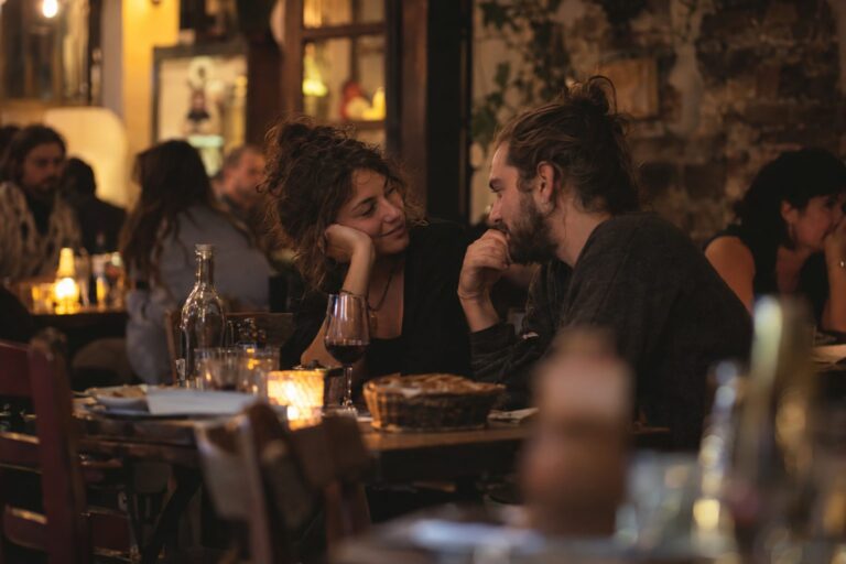 Δύο άνθρωποι κοιτάζονται ο ένας τον άλλον, τα σύμβολα Ζυγού και Υδροχόου και καρδιές γύρω τους μαρτυρούν αγάπη, σχέση και ελευθερία.