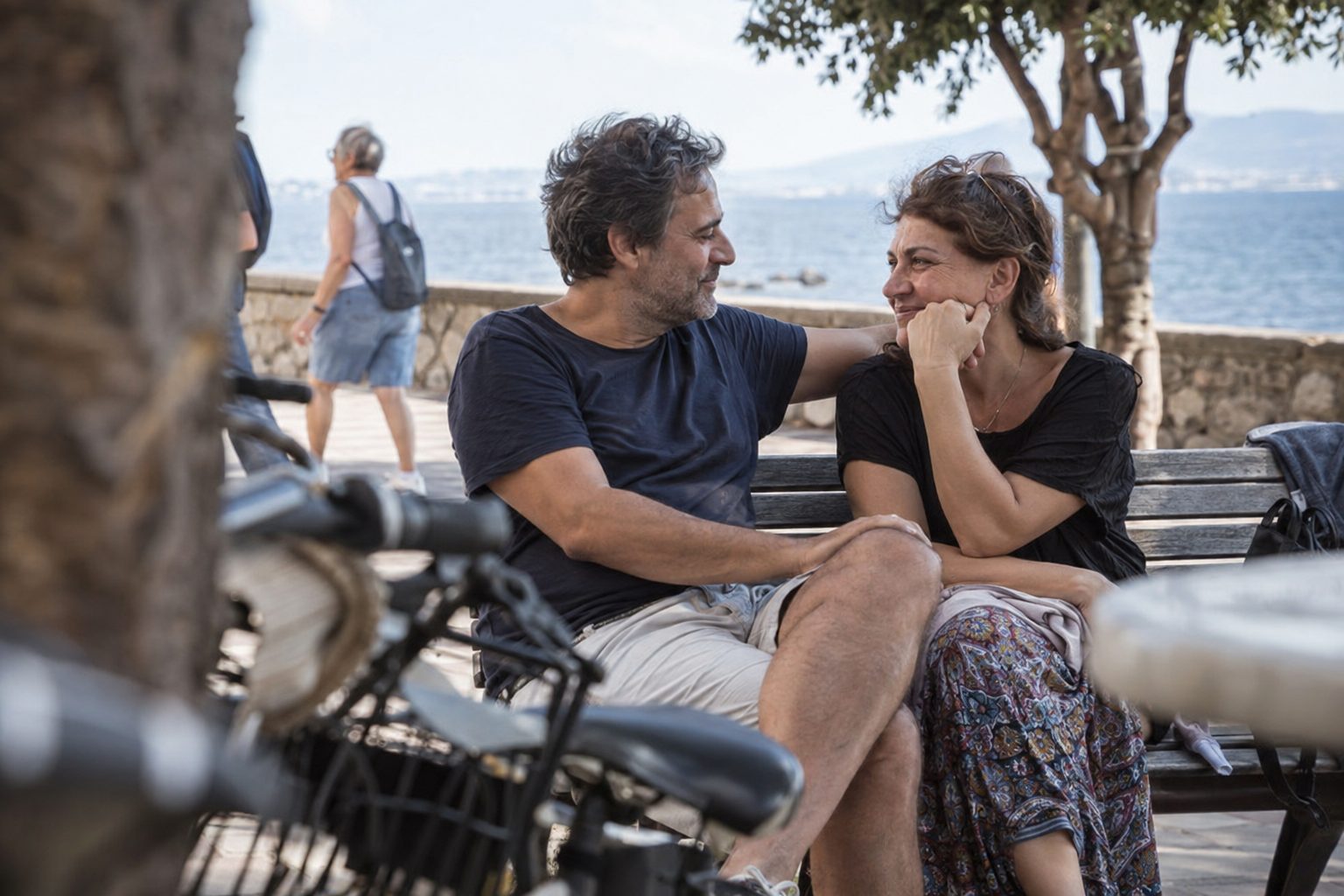 Ζευγάρι κάθεται κοντά, κρατούν τα χέρια και χαμογελούν, μαρτυρώντας επανασύνδεση και επαφή στη σχέση.