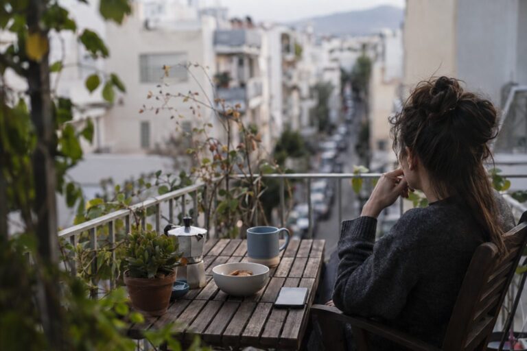 Άτομο Παρθένος κάθεται σε τραπέζι, κρατά λίστα με συνήθειες, συνδέοντας οργάνωση με ηρεμία στη σχέση.