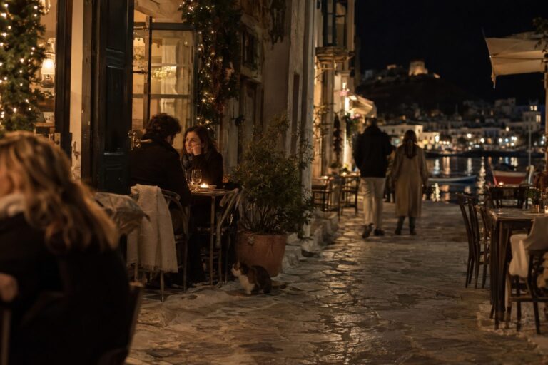 Ζευγάρι μπροστά σε χριστουγεννιάτικο δέντρο με φώτα και κεριά, συζητά συμβουλές για πρώτα ραντεβού και όρια.