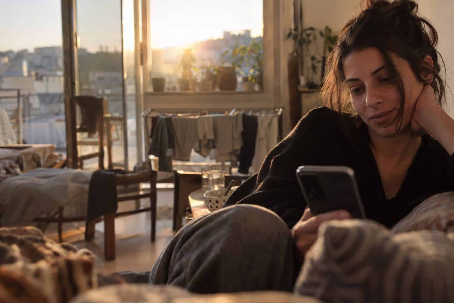 Δύο άτομα με κινητό βλέπουν οθόνη συνομιλίας με γραφικά για το 2026 στις γνωριμίες και εφαρμογές.